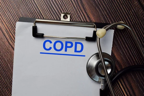 COPD, ahşap masaya izole edilmiş bir evrak yazacak..