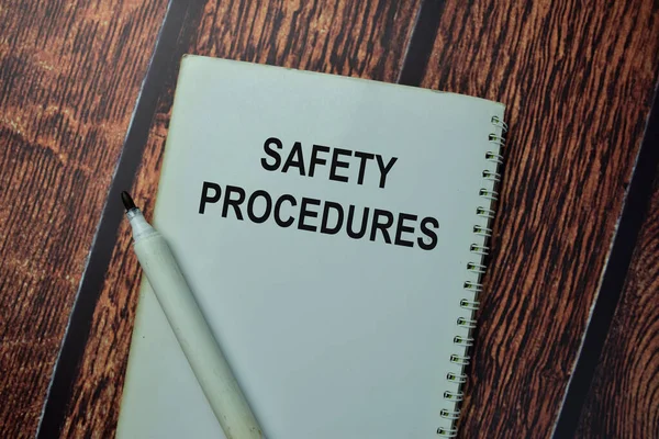 Safety Procedures write on a book isolated on office desk.