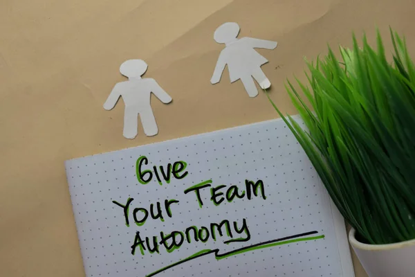 Give Your Team Autonomy write on a book isolated on office desk.