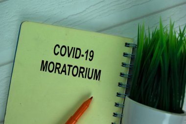 Covid-19 Moratorium ofis masasındaki izole bir kitaba yazı yazacak..