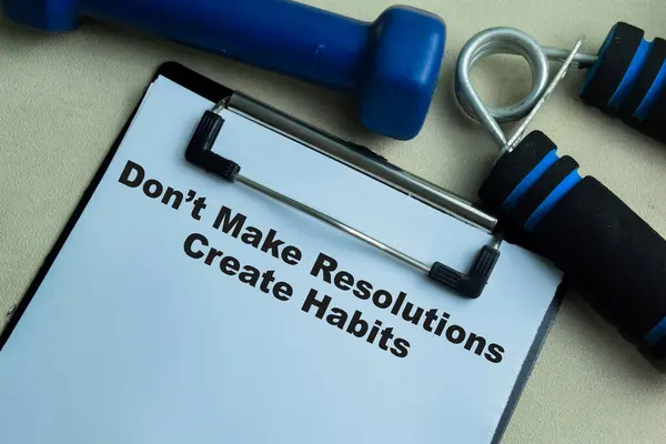 Concept of Don\'t Make Resolutions Create Habits write on paperwork isolated on wooden background.