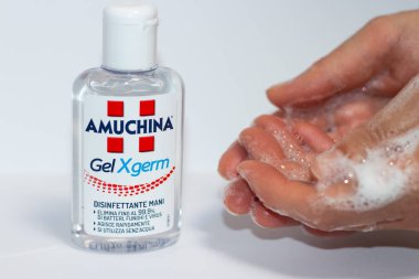 Benevento / İtalya - 27 Nisan 2020: Bulaşıcı virüs, mantar ve bakterileri azaltmak için sabunlu eller ve AMUCHINA Gel XGERM el dezenfektanı.
