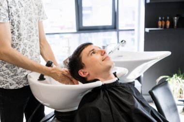 Yakışıklı müvekkilinin için saç yıkama Kuaför. İş yerinde berber. Berber dükkanı adama.