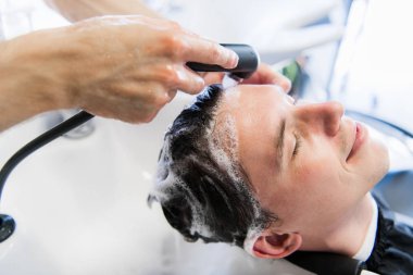 Kuaförü Kuaför müşteri saç - genç adam Güzellik Güzellik salonunda rahatlatıcı yıkama