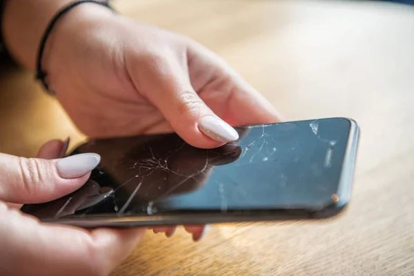 Kadının el ile siyah bir cep telefonu olan ekran bozuldu görünümü Kapat.