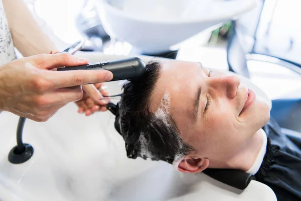 Enjeksiyon almadan önce genç adam onun saç saç kaybı sorun ile yıkanmış