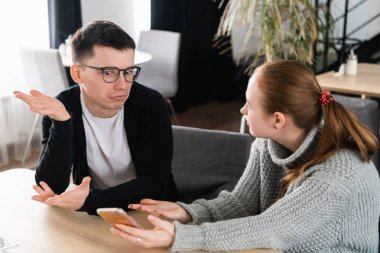 Kafede bir kanepede oturan erkek açıklaması için soran kız