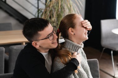 Kafede romantik çift güzel sürpriz. Adam kız gözlerini onun için bir sürpriz bekliyor iken koruyor