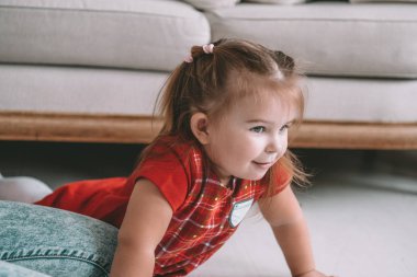 Küçük sevimli düşünceli kız modern evde oturma odasında bir yerde yatarken hayal kapatın