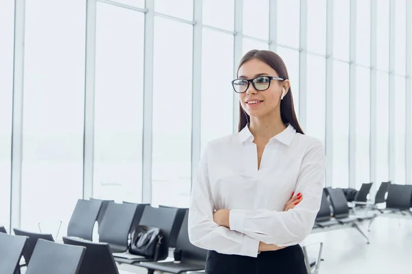 Portrait of smiling attractive business woman in airport hall. Copy space.