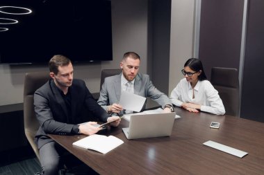 İş ortakları toplantıda belge ve fikirleri tartışıyor