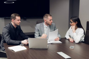 İş ortakları toplantıda belge ve fikirleri tartışıyor