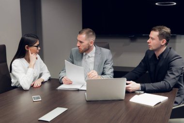 İş ortakları toplantıda belge ve fikirleri tartışıyor