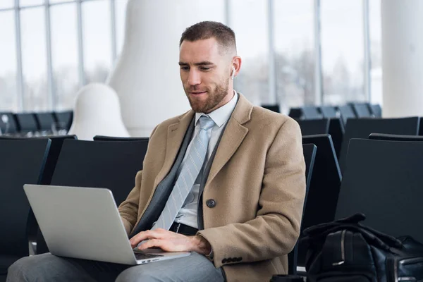 Mutlu işadamı laptop Havaalanı bekleme salonunda çalışıyor. Yakışıklı beyaz işadamı Havaalanı terminal bekleme odasında