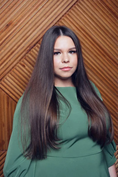 Artı uzun kahverengi saçlı bir model portresi. Sağlıklı ve güzel saçları olan alımlı güzel bir kadın.