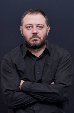 Ciddi, ciddi, ciddi, güçlü, Genç, sakallı gizli eller erkek siyah gömlek ile portresi
