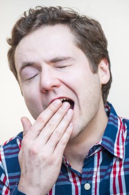 Genç yorgun esneme kıvırcık adam portresi palm beyaz arka plan üzerine açık ağzı kapsar.