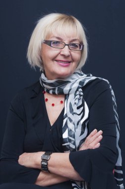 Oturma gülümseyen çekici sarışın Olgun kadın gözlük ve siyah beyaz kaşkollu portresi