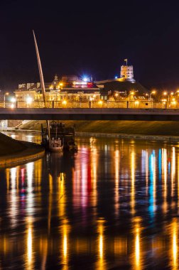 Vilnius, Litvanya - 9 Mart 2014. Neris Nehri, beyaz köprü, Lance, Old Town ve şafak kule heykeli gece cityscape bakış