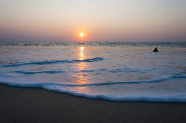 Burada Arap Denizi beach yukarıda güzel bir gün batımı bakalım, yüzme ve suda oynarken evlat ve bir deniz kadar uzak ufukta gemi. İnanılmaz Hindistan.