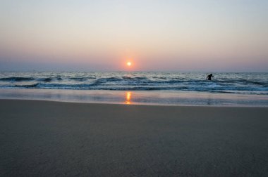 Burada Arap Denizi beach yukarıda güzel bir gün batımı bakalım, yüzme ve suda oynarken evlat ve bir deniz kadar uzak ufukta gemi. İnanılmaz Hindistan.