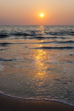 Burada çok uzak ufukta gemi Umman Denizi plaj ve bir deniz güzel bir gün batımı yukarıda görebilirsiniz. İnanılmaz Hindistan.