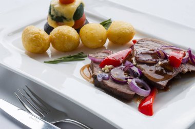 Ana yemekler. Soğan sos, biber, fırında patates, domates, kabak ve peynir ile sığır eti.