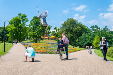 Bremen, Germany - June 12, 2011: Summer actions in Wallanlagen Park in Bremen Germany. Tourists and locals spending time in this cozy vibrant park with famous windmill in its center.