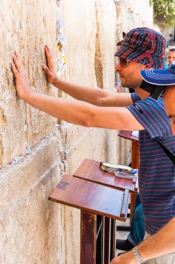 Jerusalem, İsrail - 25 Mayıs 2012: ayakta, Tanrı'dan sormak ne düşünüyor ve Batı Duvarı ' eski şehir Kudüs'te Yahudi Tapınağı kalıntıları olan kutsal taşlar dokunmak turist genç adam