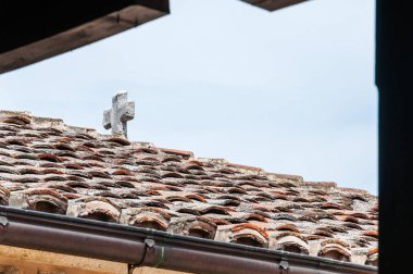 Beyaz Katolik taş kiremitli çatıya üstünde tepe-in çapraz
