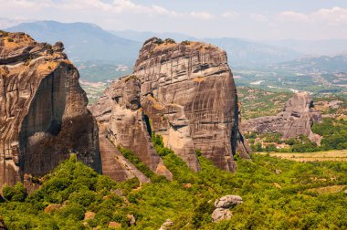 Meteora kaya oluşumları kayalıklarla ve canlı yeşil bitki örtüsü, bitkiler ve ağaçlar Yunanistan çevrili tepeleri doğal manzaralı