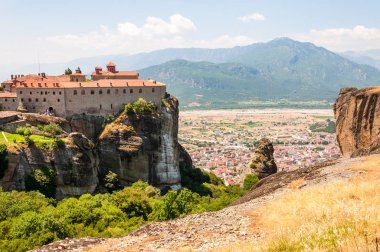 Meteora, Yunanistan - 16 Haziran 2013: Panoramik manzaralı Meteora manzara kaya oluşumları üzerinde Saint Stephen Rahibe Manastırı manastırın cliff ve hemen dağın üzerinde Kalabaka kasabanın
