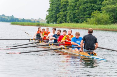 Trakai, Litvanya - 26 Temmuz 2013: bir turist nasıl sekiz kürek Galve göl sularının eserlerinde tekne öğretim eğitmen koç. Sekiz rekabet kürek Sporda kullanılan bir kürek tekne olduğunu.