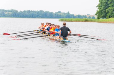Trakai, Litvanya - 26 Temmuz 2013: bir turist nasıl sekiz kürek Galve göl sularının eserlerinde tekne öğretim eğitmen koç. Sekiz rekabet kürek Sporda kullanılan bir kürek tekne olduğunu.