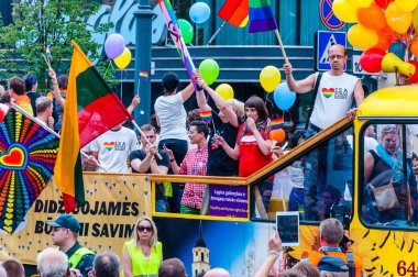 Vilnius, Litvanya - 27 Temmuz 2013: Pride parade olay eylem. Gökkuşağı barış bayrakları ile göstericiler tam renkli balonlarla süslenmiş sarı açık üst otobüs çevreleyen izleyici kalabalık