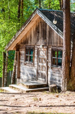 Shabby old traditional wooden forest house with wooden door entrance and two windows from both sides