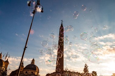 Rüzgar hava ile Piazza del Popolo yukarıda gökyüzü uçan ışık ve renkli sabun köpüğü