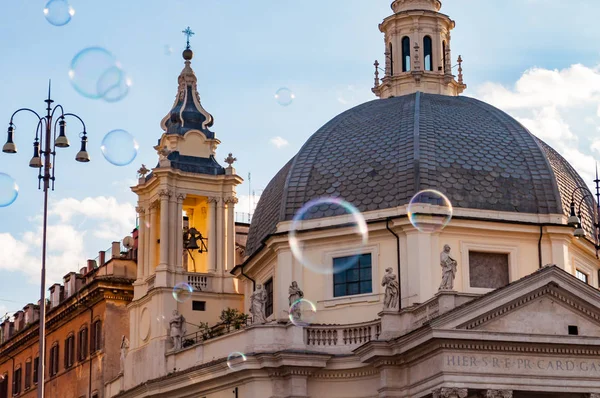 Rome, İtalya - 18 Kasım 2018: sabun köpüğü, Piazza del Popolo üzerinde uçan Halk Meydanı Roma'da antik kiliseler tarafından çevrili tarihlerde Montesanto Santa Maria ile onun büyük kubbe ve çan kulelerinin