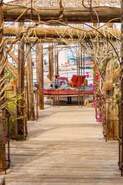 Eilat, İsrail - 21 Mart 2017: su pavyonlar ve çiftler Eilat, İsrail için ünlü yunuslar Beach içinde dinlenme ile ahşap yürüyüş yolları üzerinde