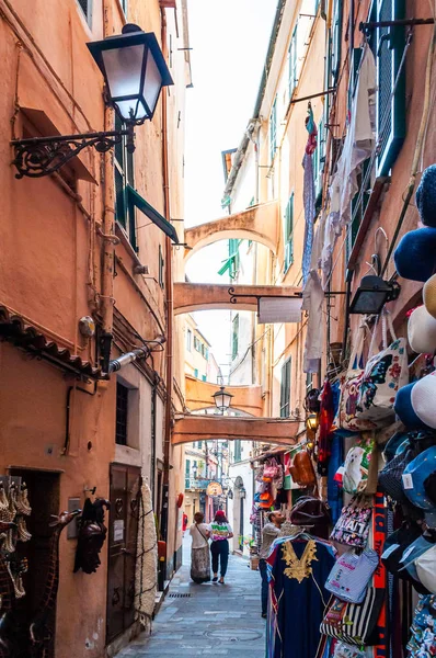 Gente caminando por la estrecha antigua calle medieval del casco antiguo llena de arcos en Sanremo, Italia . — Foto de Stock