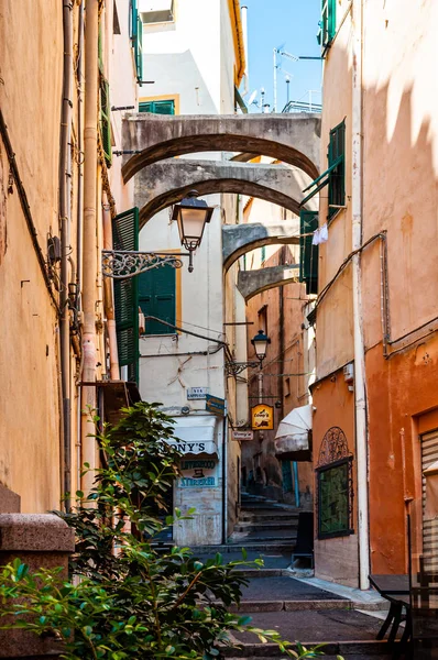 Smala gamla medeltida gamla stan gata full av lyktor, konstruktions bågar hängande mellan byggnaderna fasader — Stockfoto
