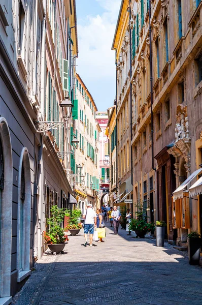 Gente caminando por la estrecha antigua calle medieval del casco antiguo en Sanremo, Italia . — Foto de Stock