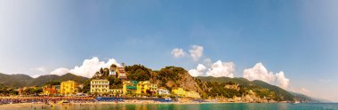 Kayalık marina manzarası, Ligurian Denizi 'nin berrak suyu, deniz gemileri, insanlarla dolu plaj, Monterosso Al Mare, Cinque Terre, İtalya' daki liman binaları.