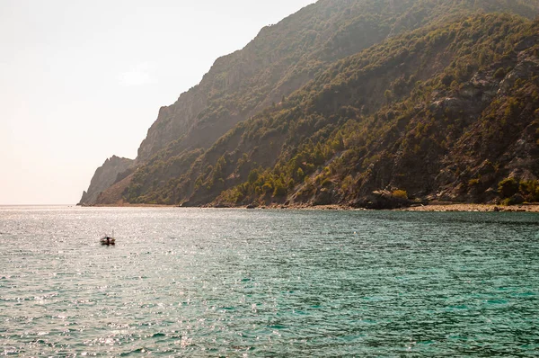 Un solo barco cerca de la costa rocosa con altas montañas verdes en Monterosso Al Mare, Cinque Terre — Foto de Stock