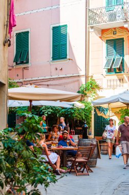 İnsanlar Monterosso Al Mare, Cinque Terre, İtalya 'nın rahat sokaklarında restoran ve barlarda oturuyorlar.