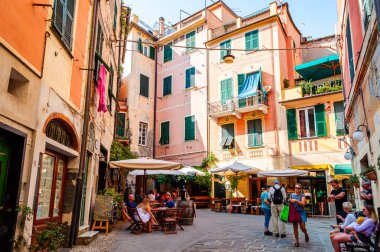 İnsanlar Monterosso Al Mare, Cinque Terre, İtalya 'nın rahat sokaklarında restoran ve barlarda oturuyorlar.