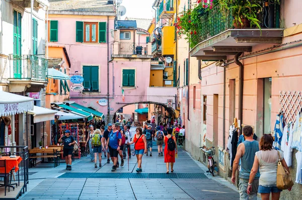 La gente está caminando, viajando por unas acogedoras calles llenas de pequeños negocios en la planta baja en Monterosso Al Mare, Cinque Terre, Italia — Foto de Stock
