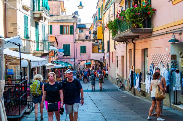 La gente está caminando, viajando por unas acogedoras calles llenas de pequeños negocios en la planta baja en Monterosso Al Mare, Cinque Terre, Italia — Foto de Stock