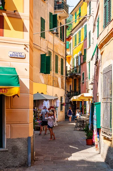 La gente está caminando, viajando por unas acogedoras calles llenas de pequeños negocios en la planta baja en Monterosso Al Mare, Cinque Terre, Italia — Foto de Stock