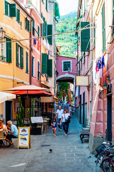 As pessoas estão caminhando, viajando por uma acolhedora ruas vibrantes cheias de pequenas empresas no piso térreo em Monterosso Al Mare, Cinque Terre, Itália — Fotografia de Stock